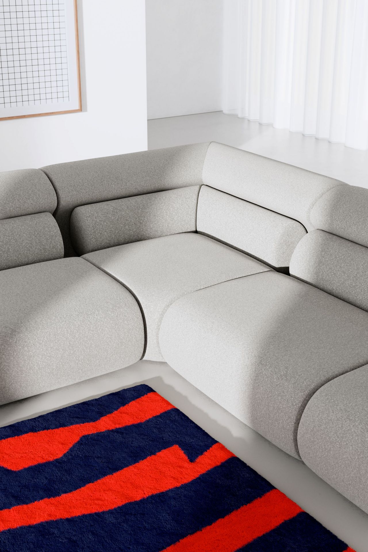 Helles OLA Sofa Lounge aus Bouclé Stoff im modernen Wohnzimmer mit Teppich.
