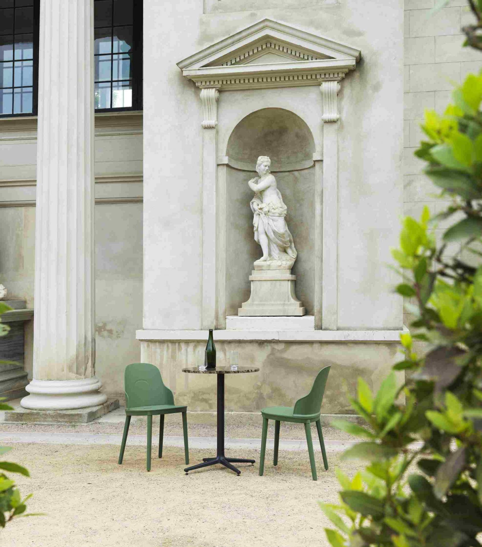Zwei grüne Allez Chair Stühle von Normann Copenhagen mit Tisch im Außenbereich vor historischer Kulisse.