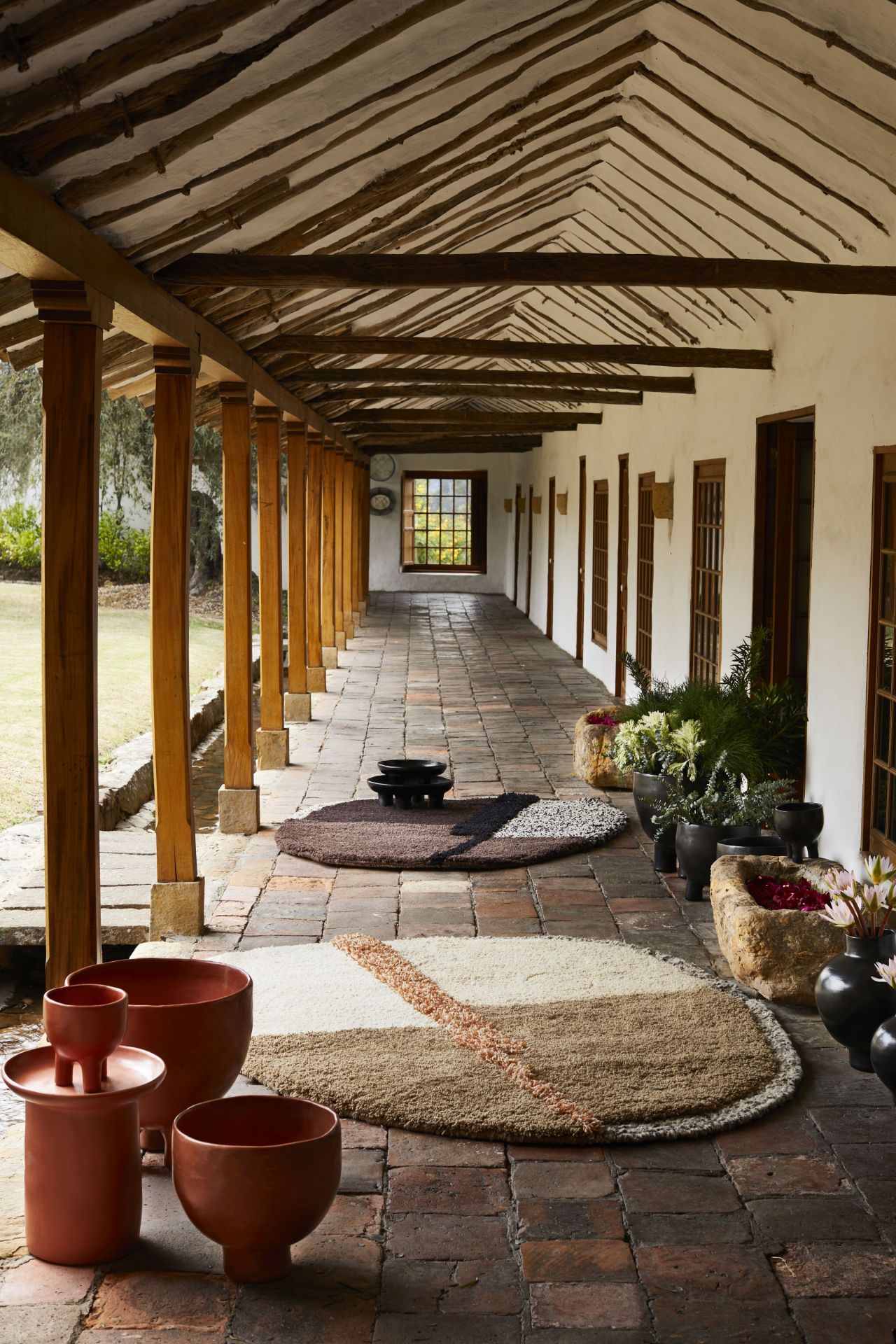 AMES Nudo Teppich Large 180x220 im Flur eines Hauses mit rustikalem Steinfußboden.