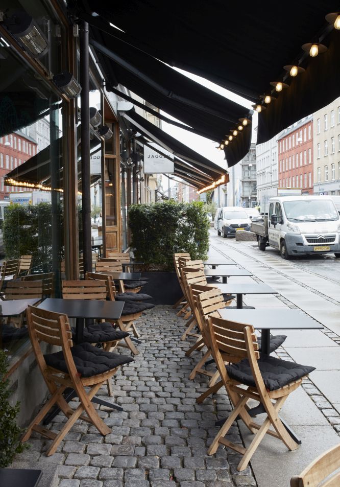 Vendia Chair Klappstühle von Skagerak by Fritz Hansen vor einem Restaurant auf einem Kopfsteinpflasterweg.