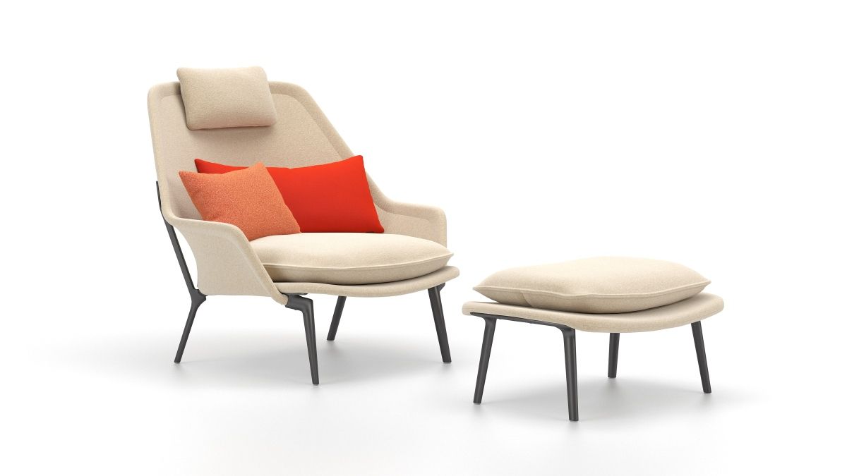 Vitra Slow Chair mit Ottoman in Stoff, beige mit roten und orangen Kissen.
