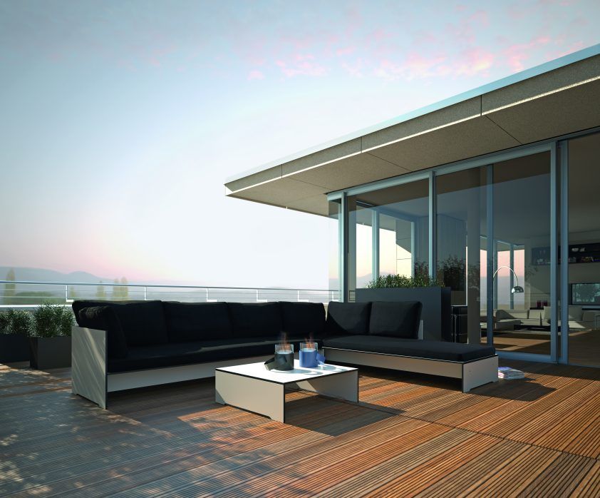 Riva Lounge Sofa von Conmoto auf einer Terrasse mit Holzboden und schwarzem Polster.