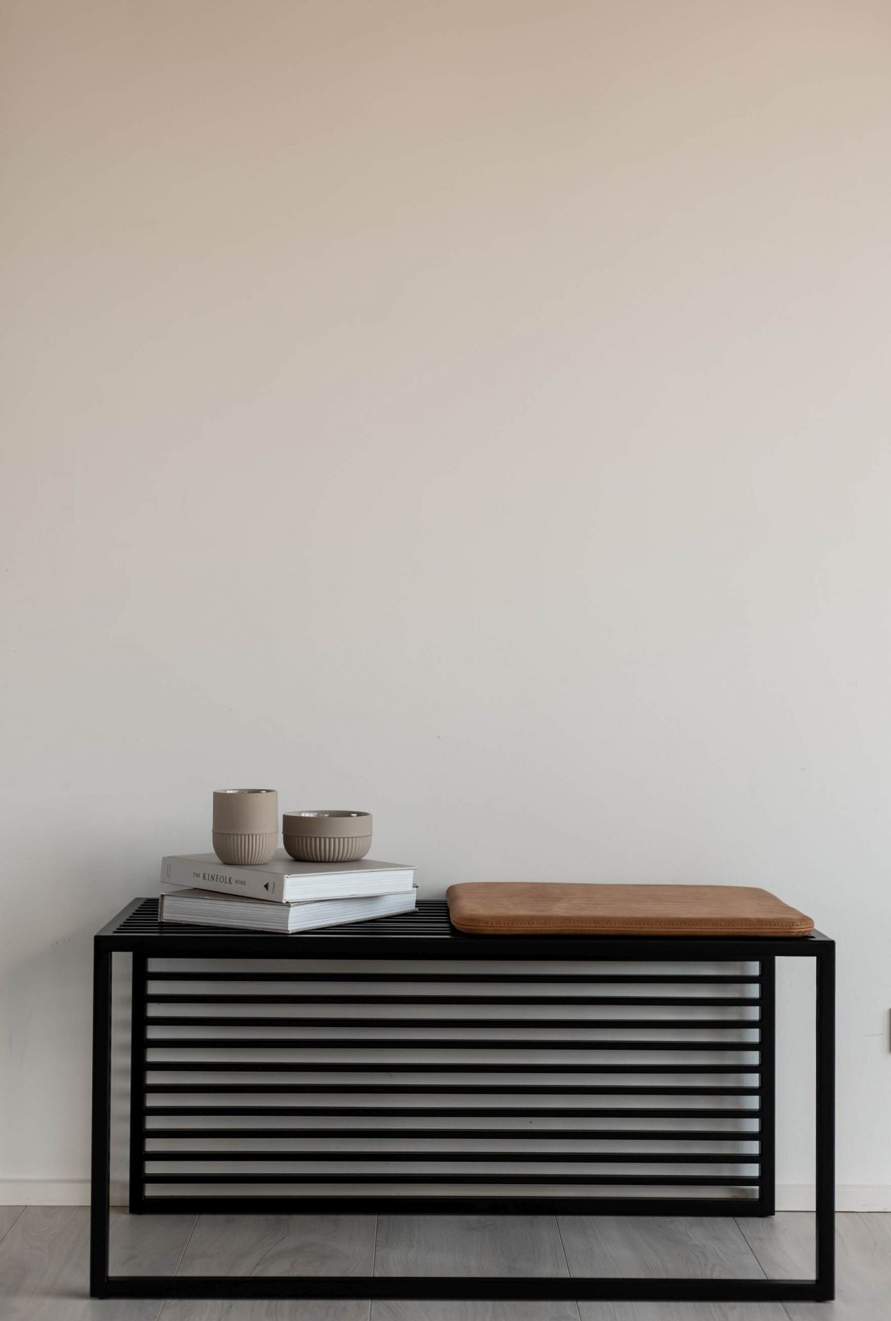 Element Bench Bank von Novoform mit schwarzem Metallgestell, Lederkissen, Büchern und Deko-Schalen.