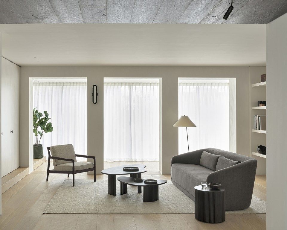 Wohnzimmer-Szene mit Ethnicraft Rollcontainer als Beistelltisch neben grauem Sofa, minimalistisches Design.
