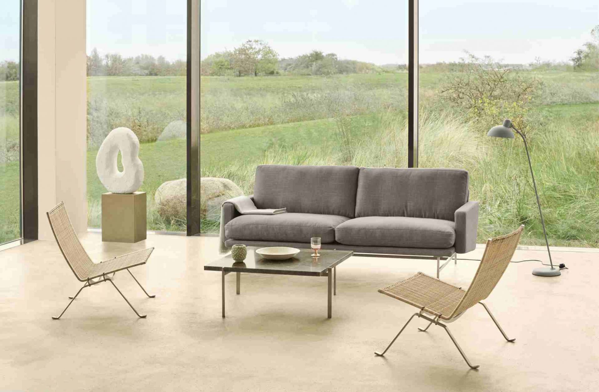 Graues Lissoni Sofa von Fritz Hansen in modernem Wohnzimmer mit Designermöbeln und großem Fenster.