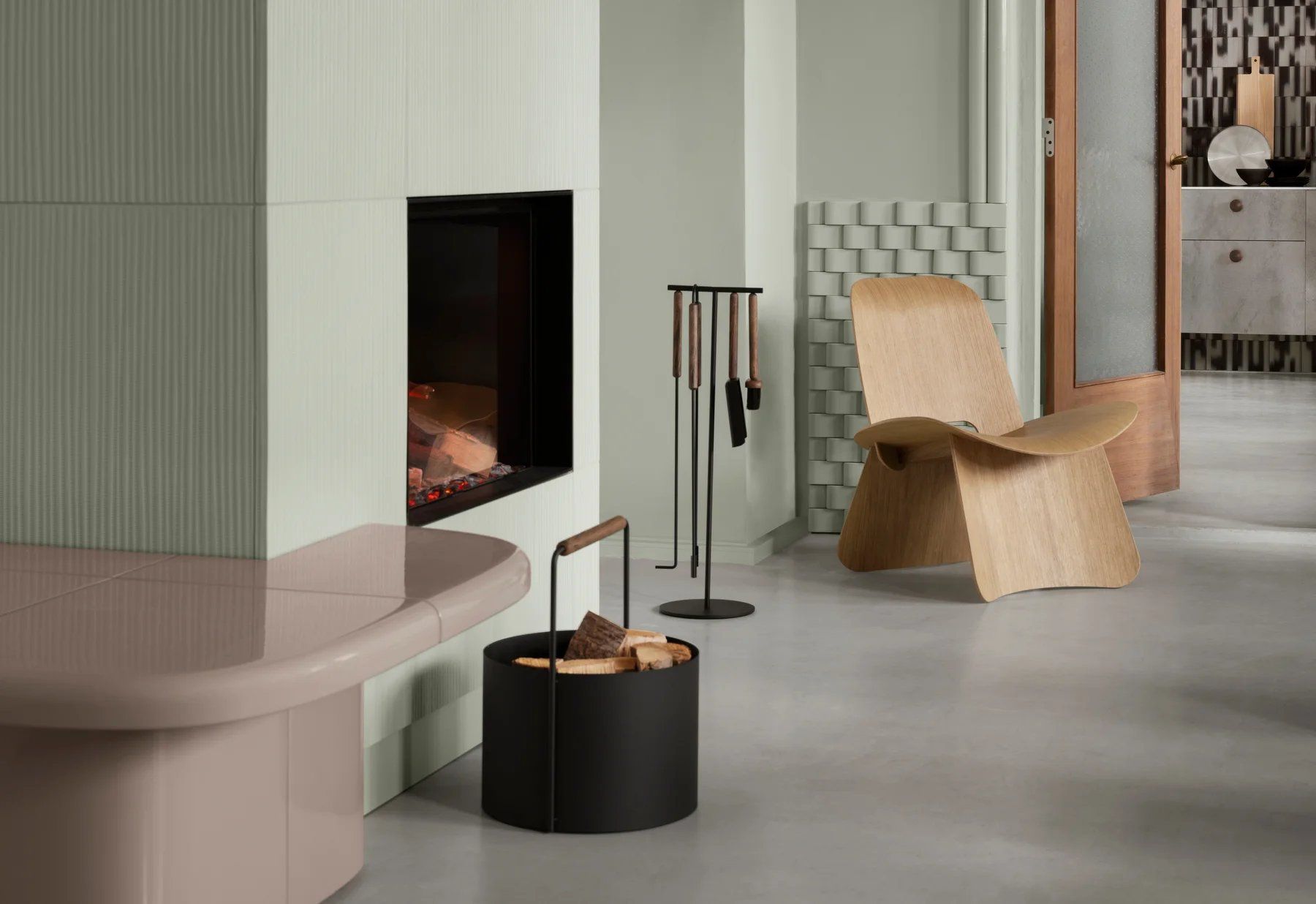 Blomus Nagomi Chair Holzstuhl im Interieur mit Kamin, Holzkorb und Kaminbesteck.