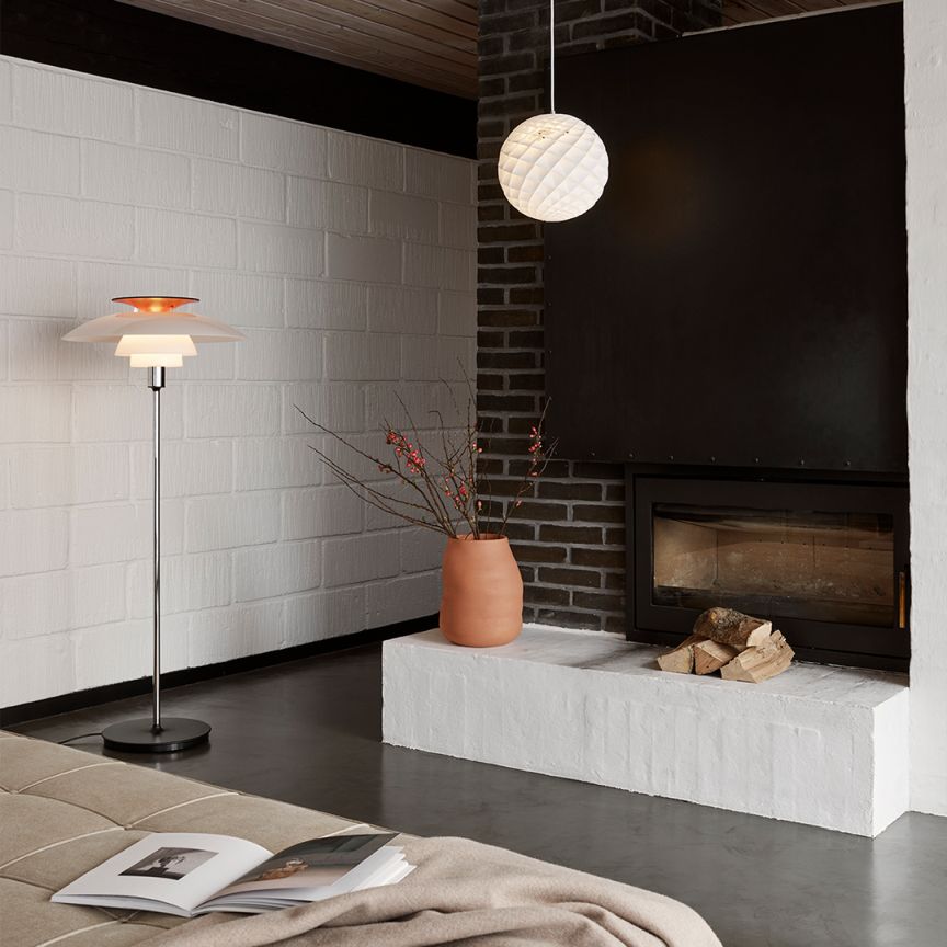Moderne Wohnraumgestaltung mit Louis Poulsen Patera Pendelleuchte und Stehleuchte für stimmungsvolle Beleuchtung am Kamin.