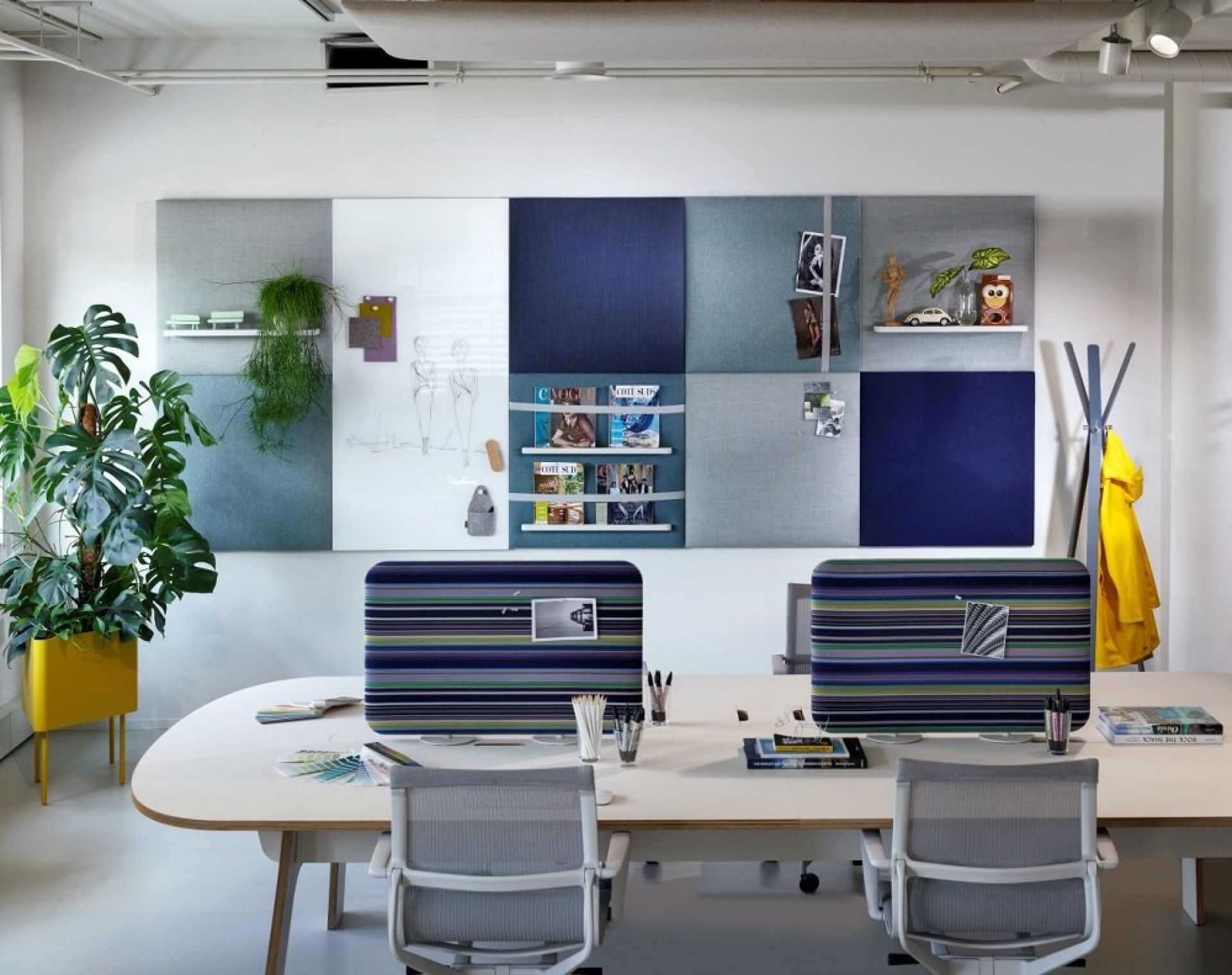 Büro mit Cascando Pillow Grid Wandpaneelen in verschiedenen Farben und Schreibtisch mit Bürostühlen.