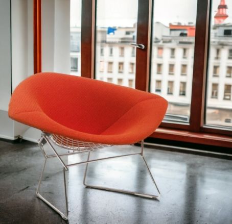Oranger Diamond Sessel von Knoll International mit Drahtgestell vor einem Fenster mit Stadtblick.