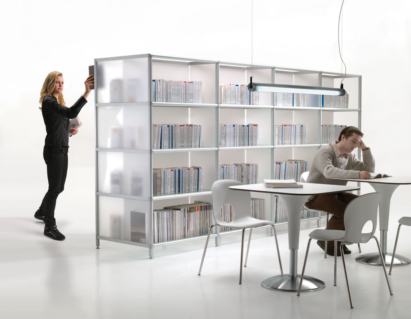 Zanziplano Tisch von Rexite mit weißen Stühlen und Bücherregal im modernen Büroambiente.