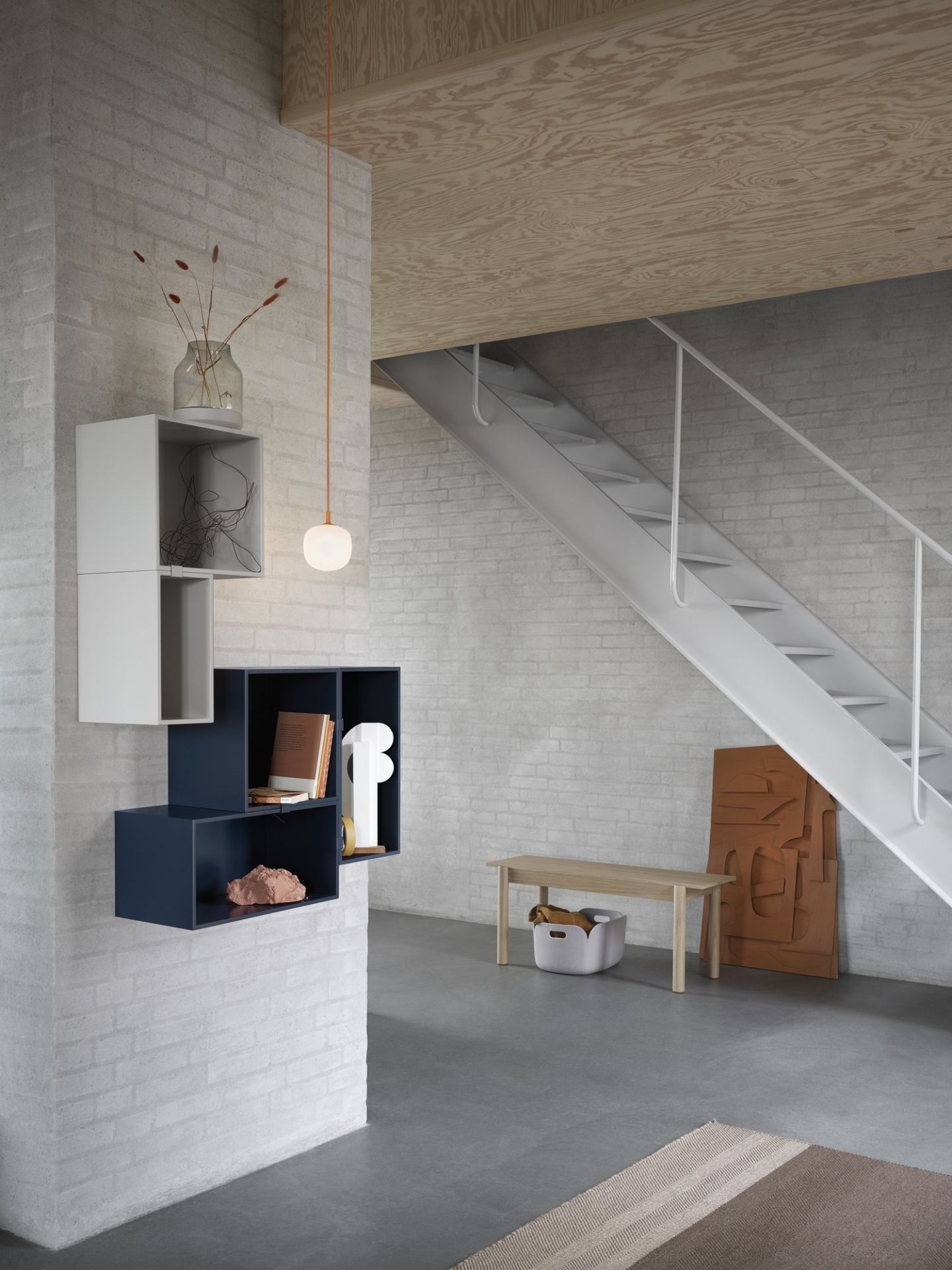 Modernes Wohnzimmer mit Muuto Stacked Storage System 2.0 Regalsystem in Weiß und Blau an der Wand.