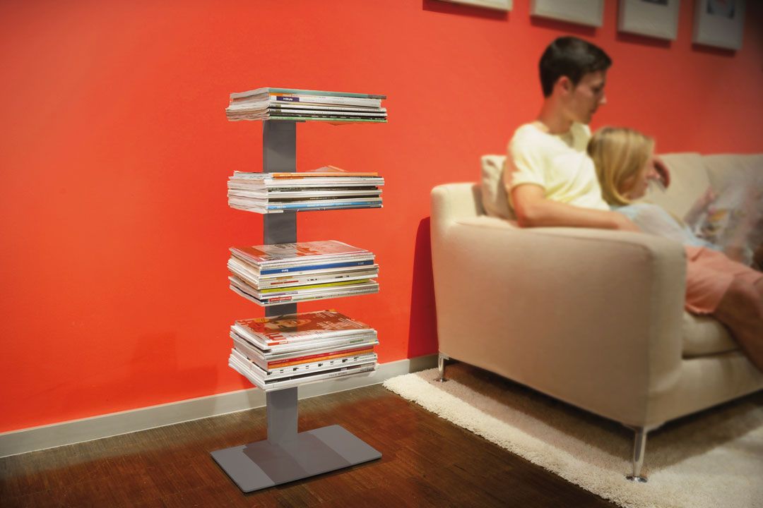 Booksbaum Magazinregal: Modernes Standregal in Weiß, gefüllt mit Zeitschriften, neben einer Couch.