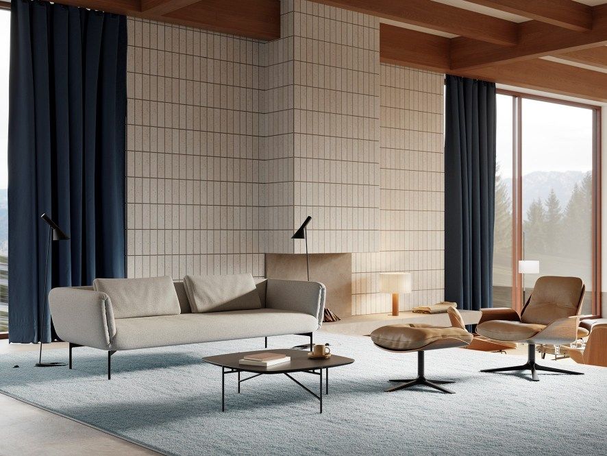 Wohnzimmer mit beigem Rei Sessel von Prostoria, Sofa, Couchtisch und braunem Ledersessel.