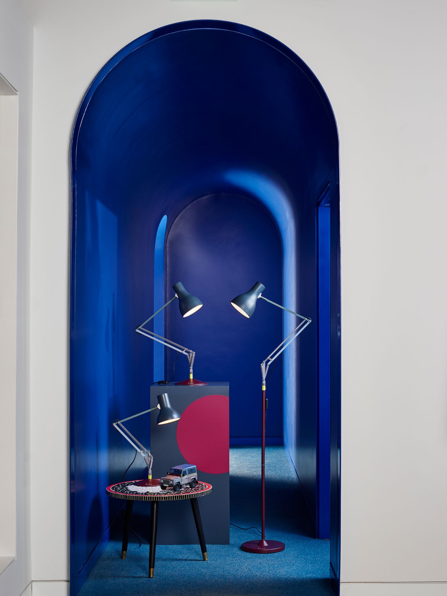 Anglepoise Type 75 Mini Paul Smith Edition 4 Tischleuchten in einem blauen Raum mit farbenfrohen Akzenten.