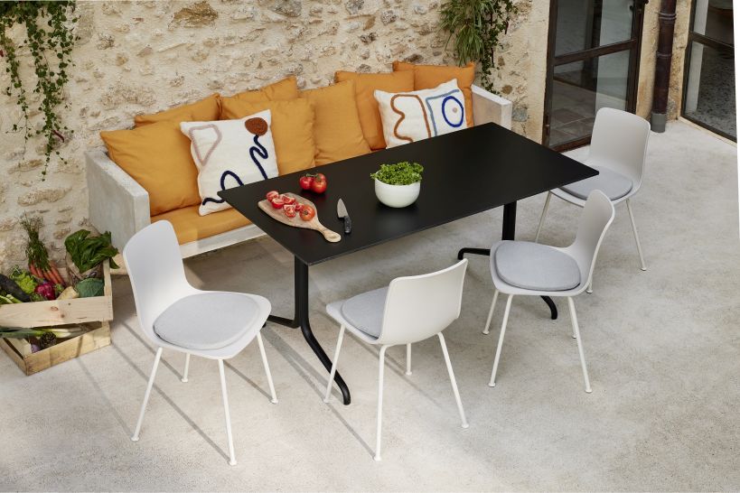 Vitra Soft Seats Sitzkissen Indoor/Outdoor, Typ A Cosy 2 Pebble grey auf Stühlen an Esstisch im Außenbereich.