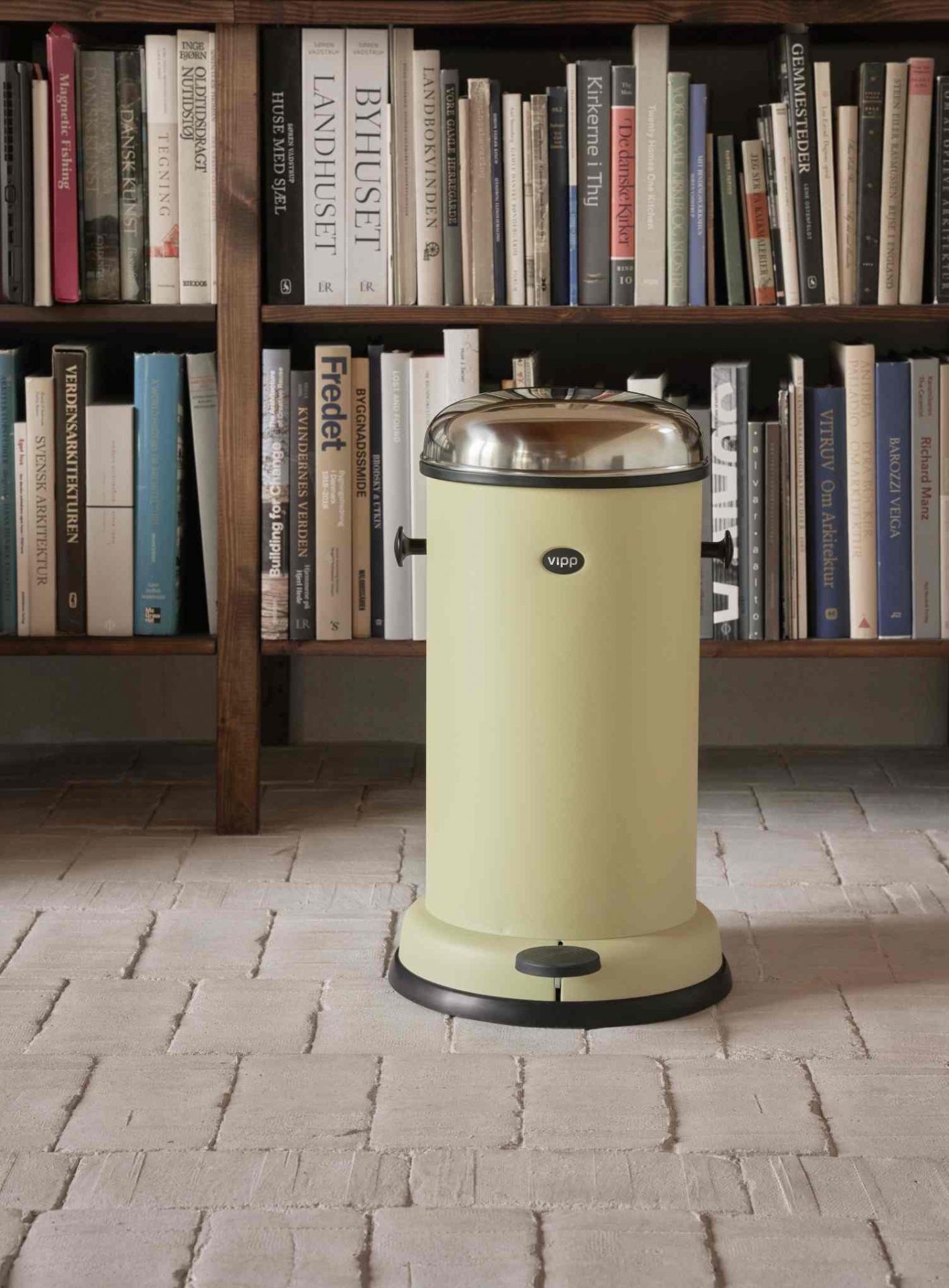 Marie´s Yellow Vipp Treteimer Limited Edition vor Bücherregal: Gelber Mülleimer aus Stahl mit Chromdeckel.