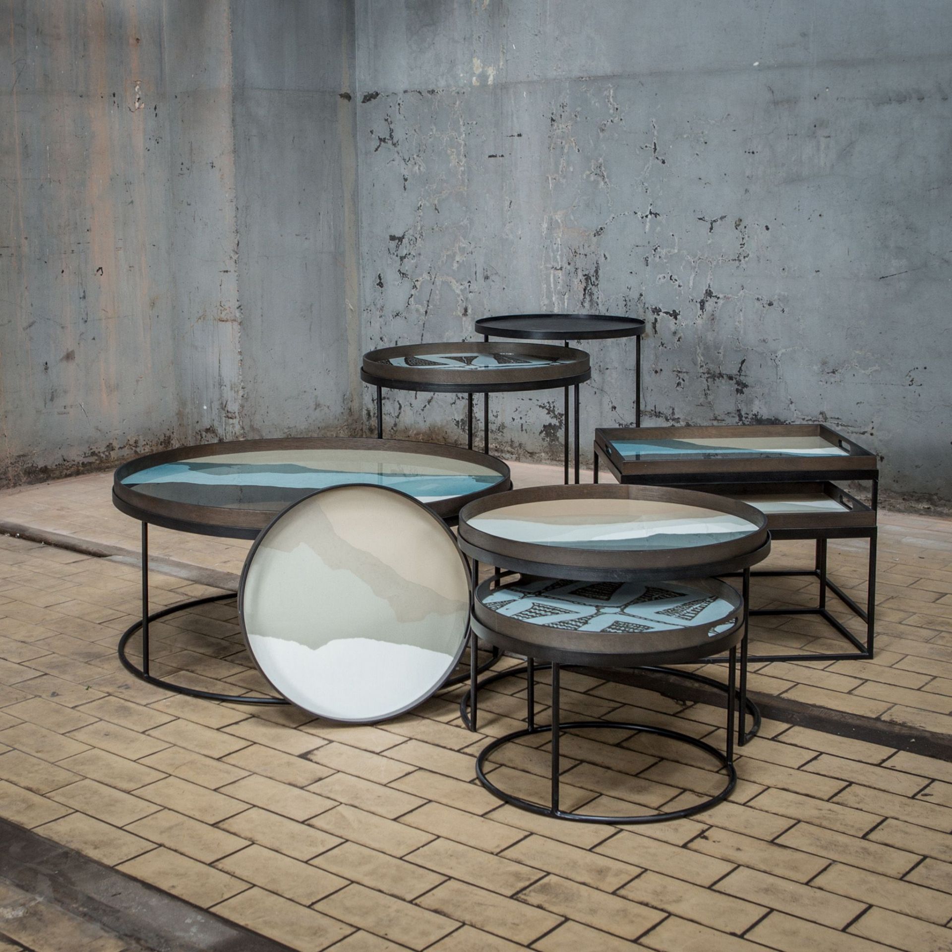 Couchtisch Set von Ethnicraft: Runde und rechteckige Tische mit schwarzem Metallgestell und farbigen Mustern.