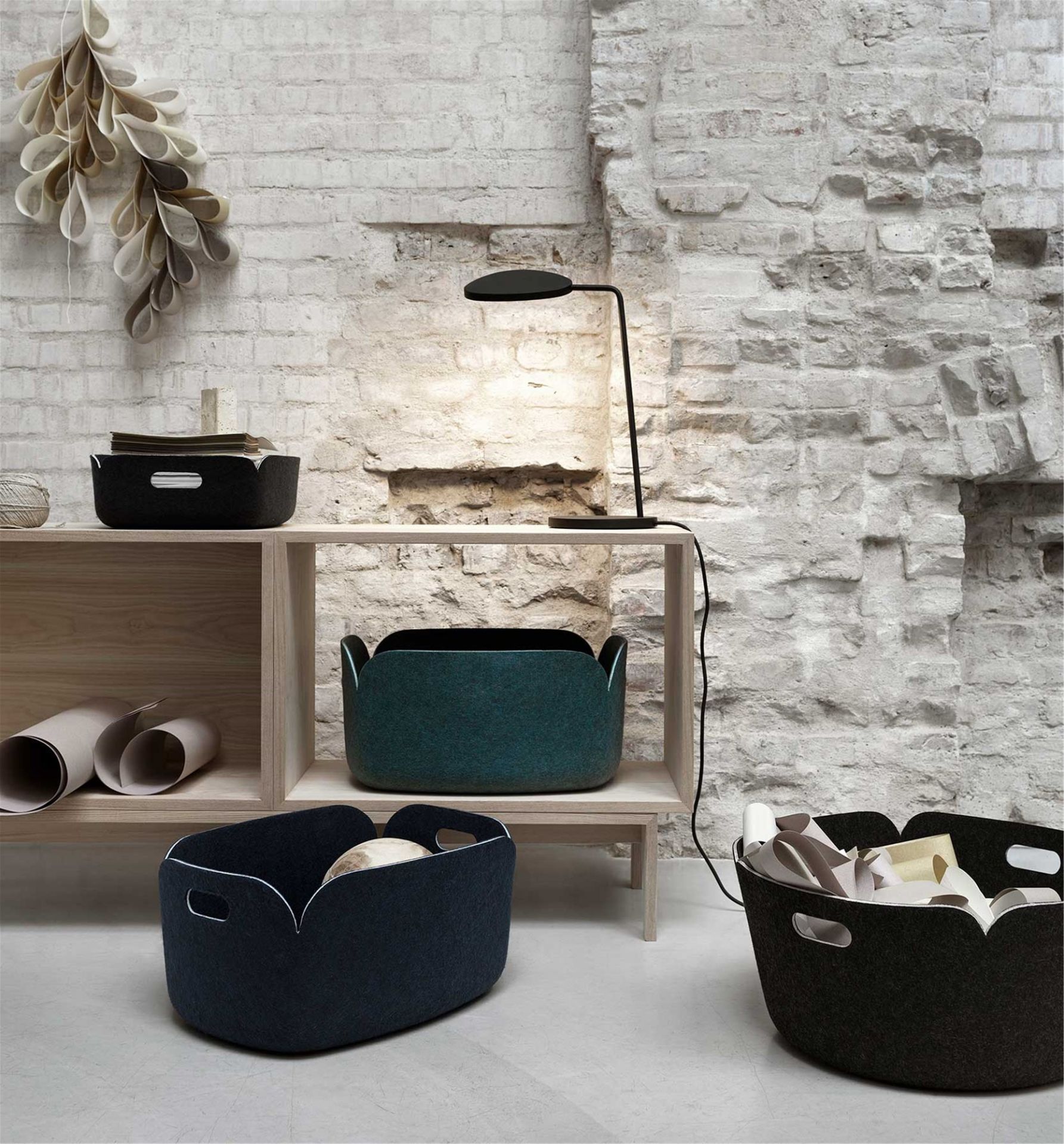 Muuto Restore Aufbewahrungskörbe in verschiedenen Farben auf einem Regal, stilvolle Filzkörbe für Ordnung.