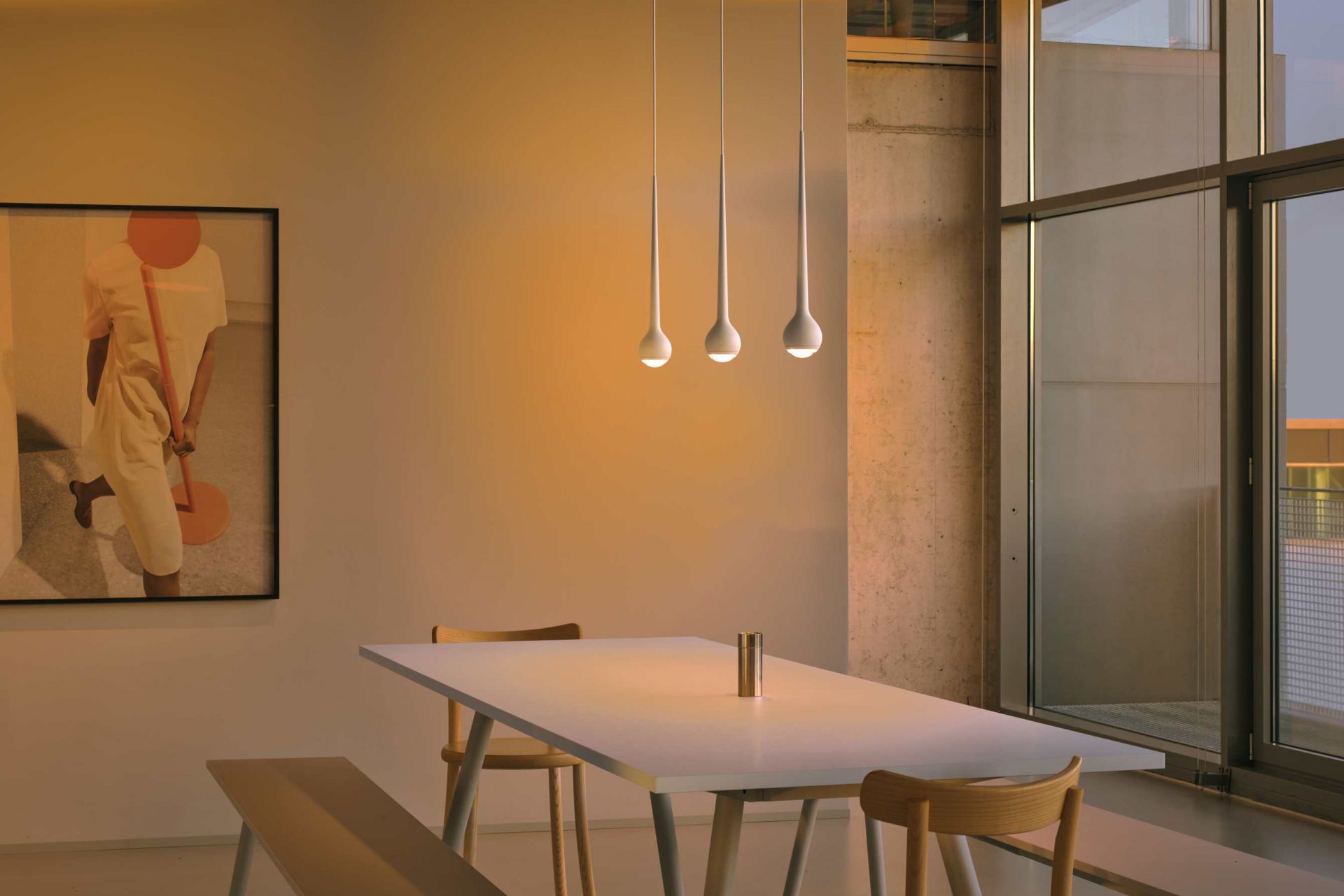 Drei graue Falling Sun Pendelleuchten über einem Esstisch in einem modern eingerichteten Esszimmer.