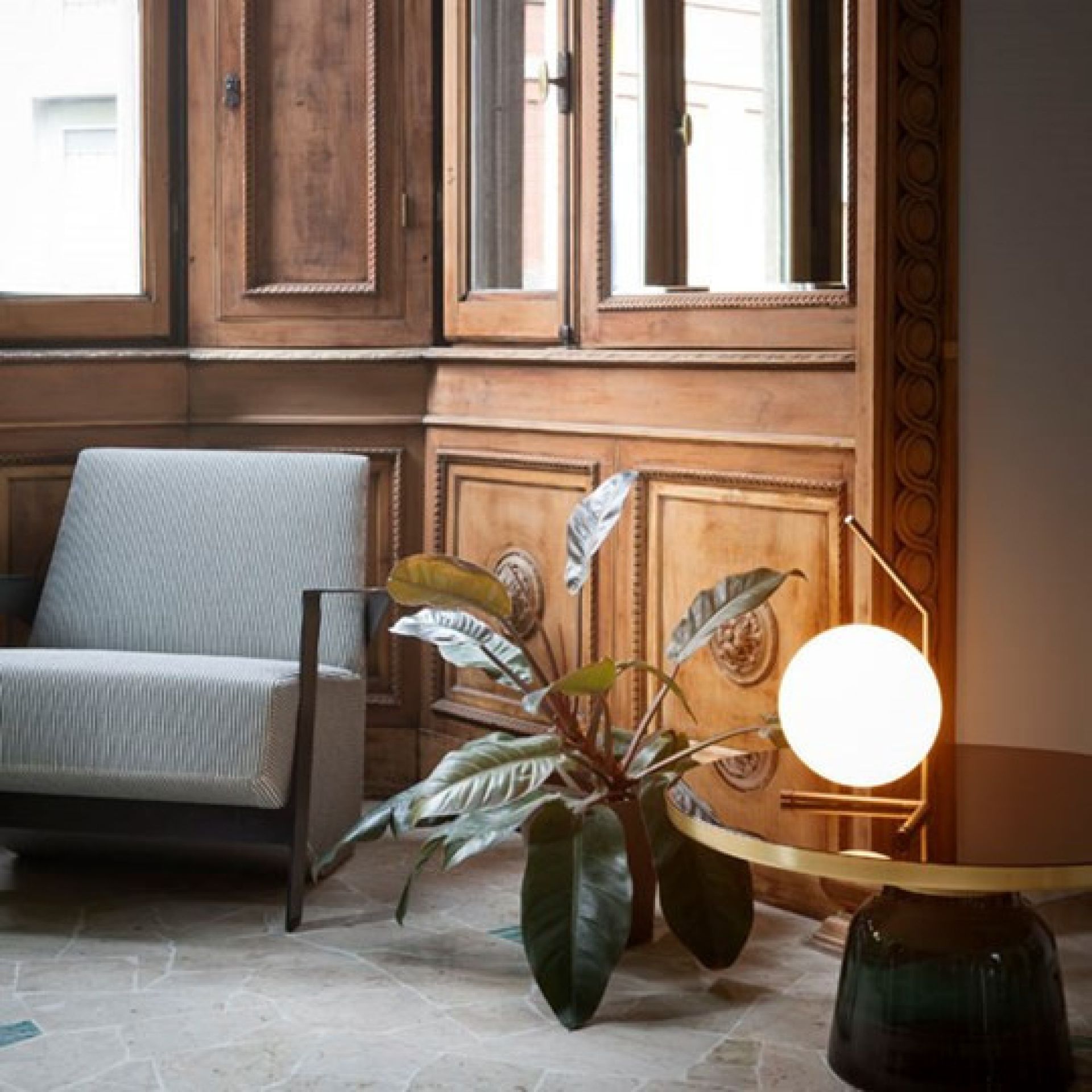 IC Lights T1 Low Tischleuchte von Flos: Moderne Kugel-Tischlampe aus Messing und Glas auf Beistelltisch.