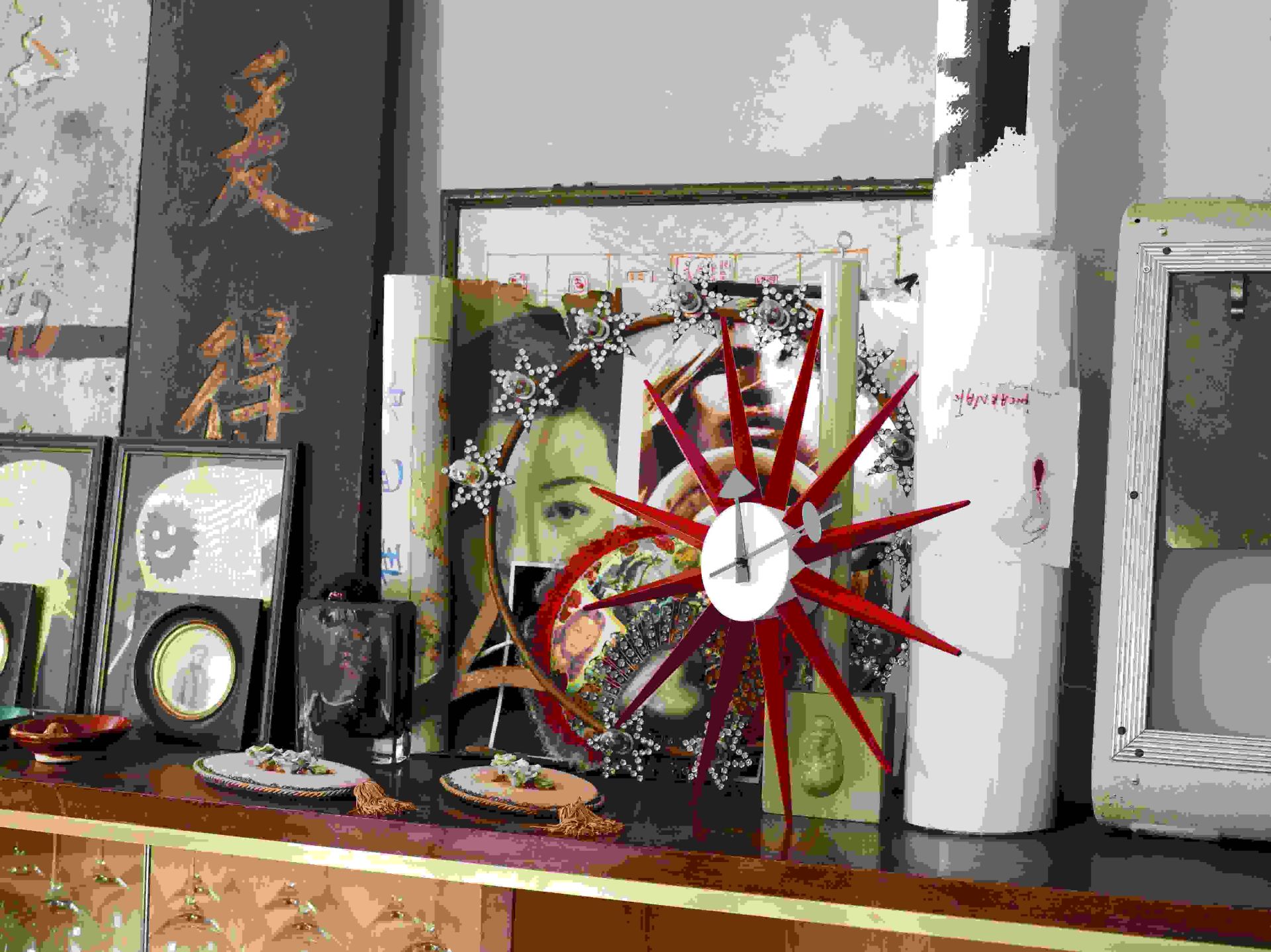 Nahaufnahme der Vitra Sunburst Clock Wanduhr in Rot, stilvolles Wohnaccessoire für moderne Interieurs.