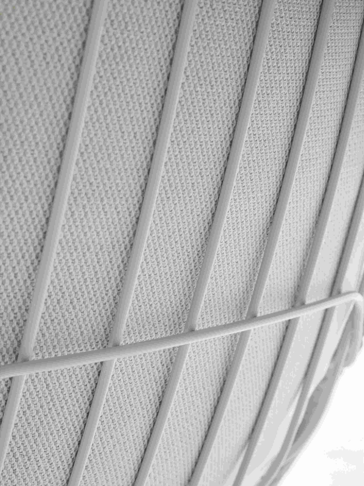 Detailaufnahme des Leyasol Lounge Chair von Freifrau Manufaktur: Graues Outdoor-Gewebe und filigranes Metallgestell des Gartenstuhls.