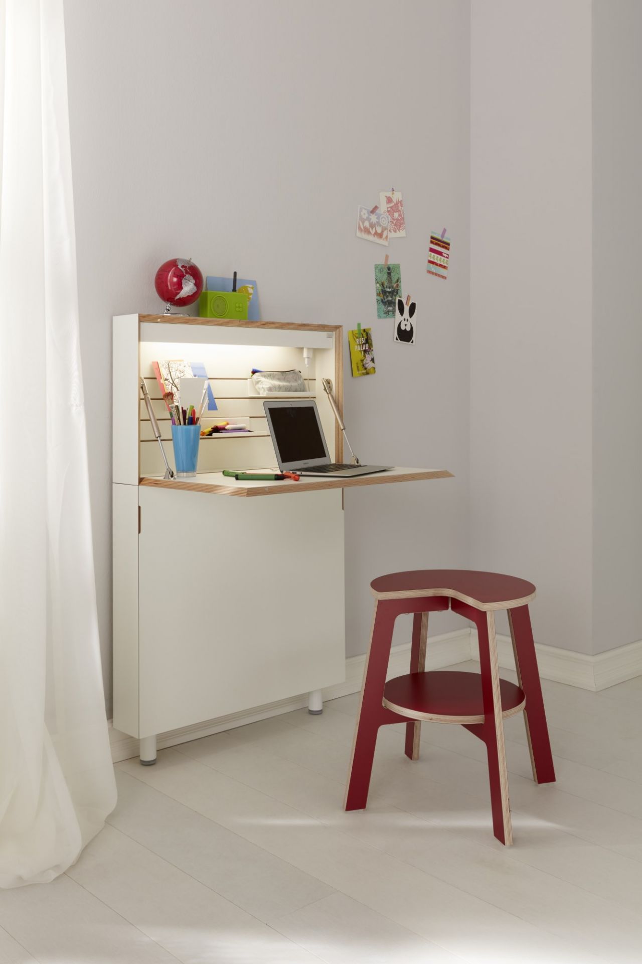 Flatmate Sekretär von Müller Möbelwerkstätten, weißer Schreibtisch mit rotem Hocker, Laptop und Schreibutensilien.