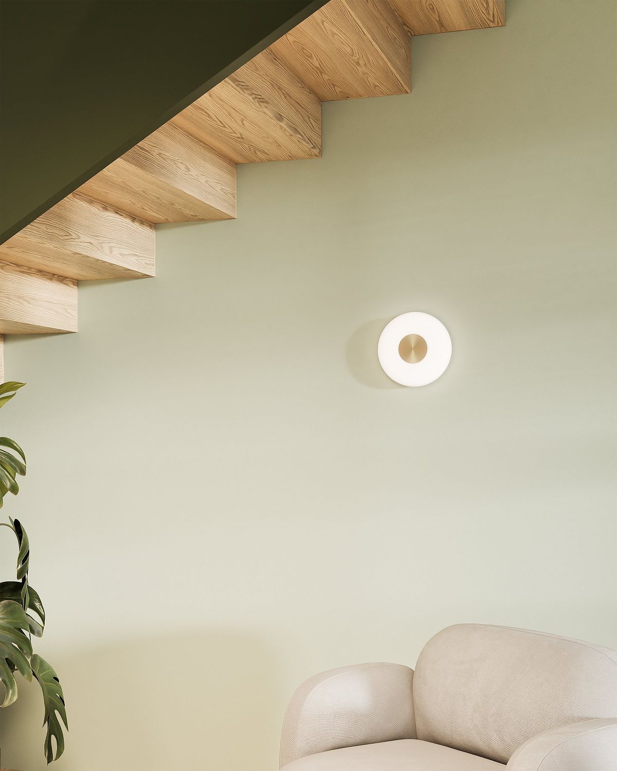 Glint Glass Wandleuchte von Northern, runde, moderne Wandlampe aus Opalglas und Messing an grüner Wand.