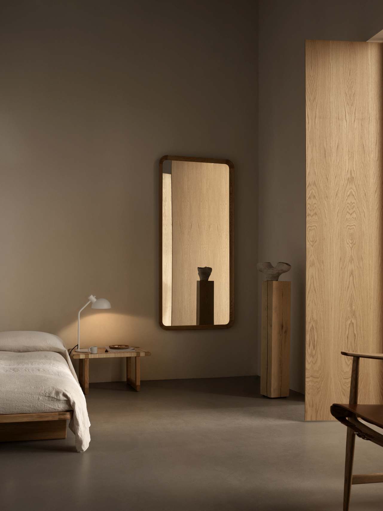 VLA62 Radio House Spiegel von Carl Hansen in Schlafzimmer mit Bett und Lampe.