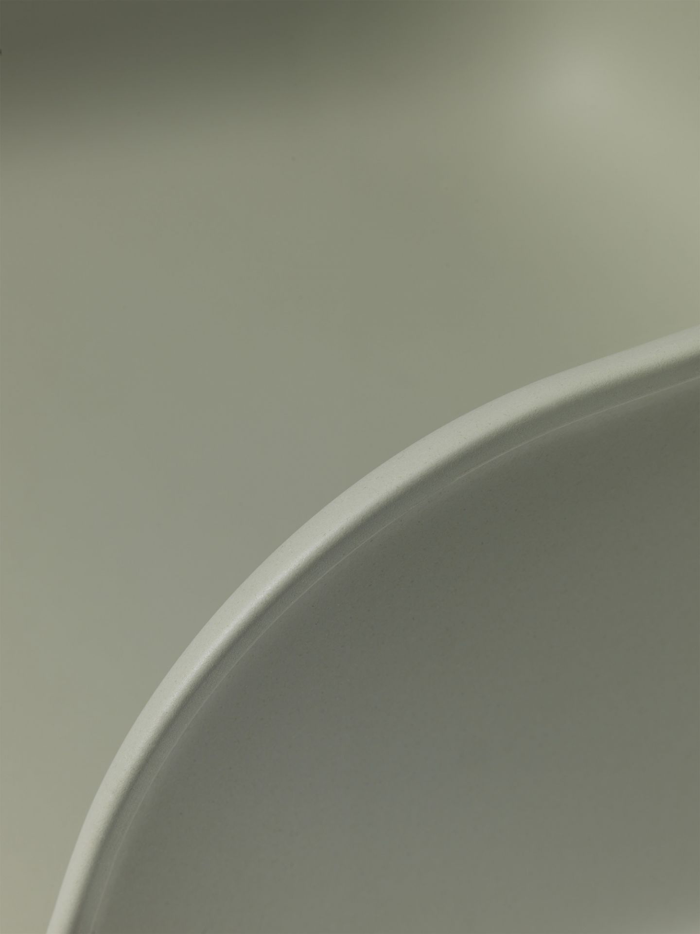 Detailaufnahme der Armlehne des grauen Fiber Armchair Stuhls von Muuto, modernes Möbeldesign.