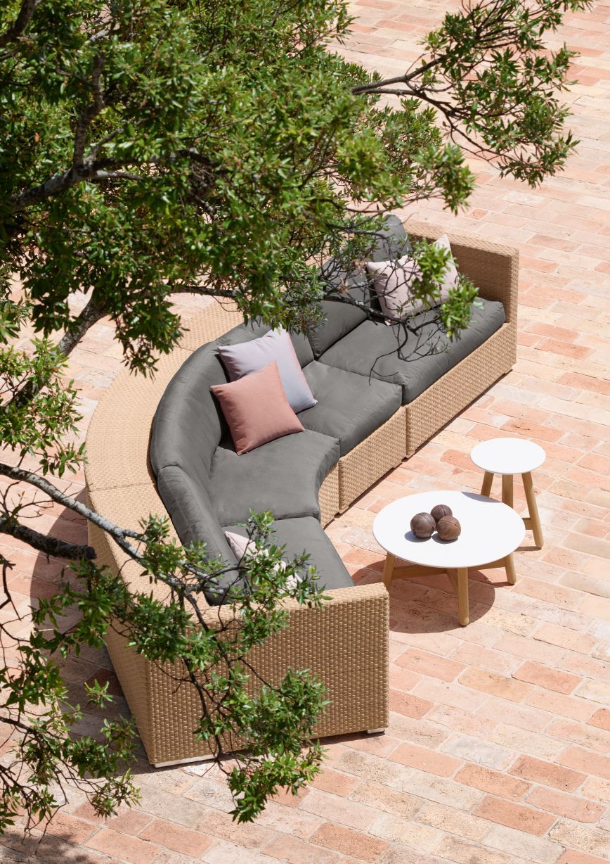 Dedon Lounge Sonnenliege mit grauen Polstern und Kissen auf einer Terrasse, Vogelperspektive.