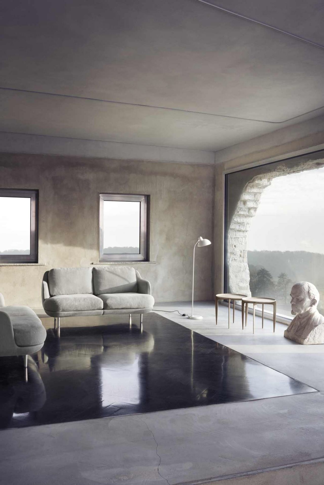 Helles Wohnzimmer mit grauem Lune Sofa von Fritz Hansen, minimalistisch und modern.