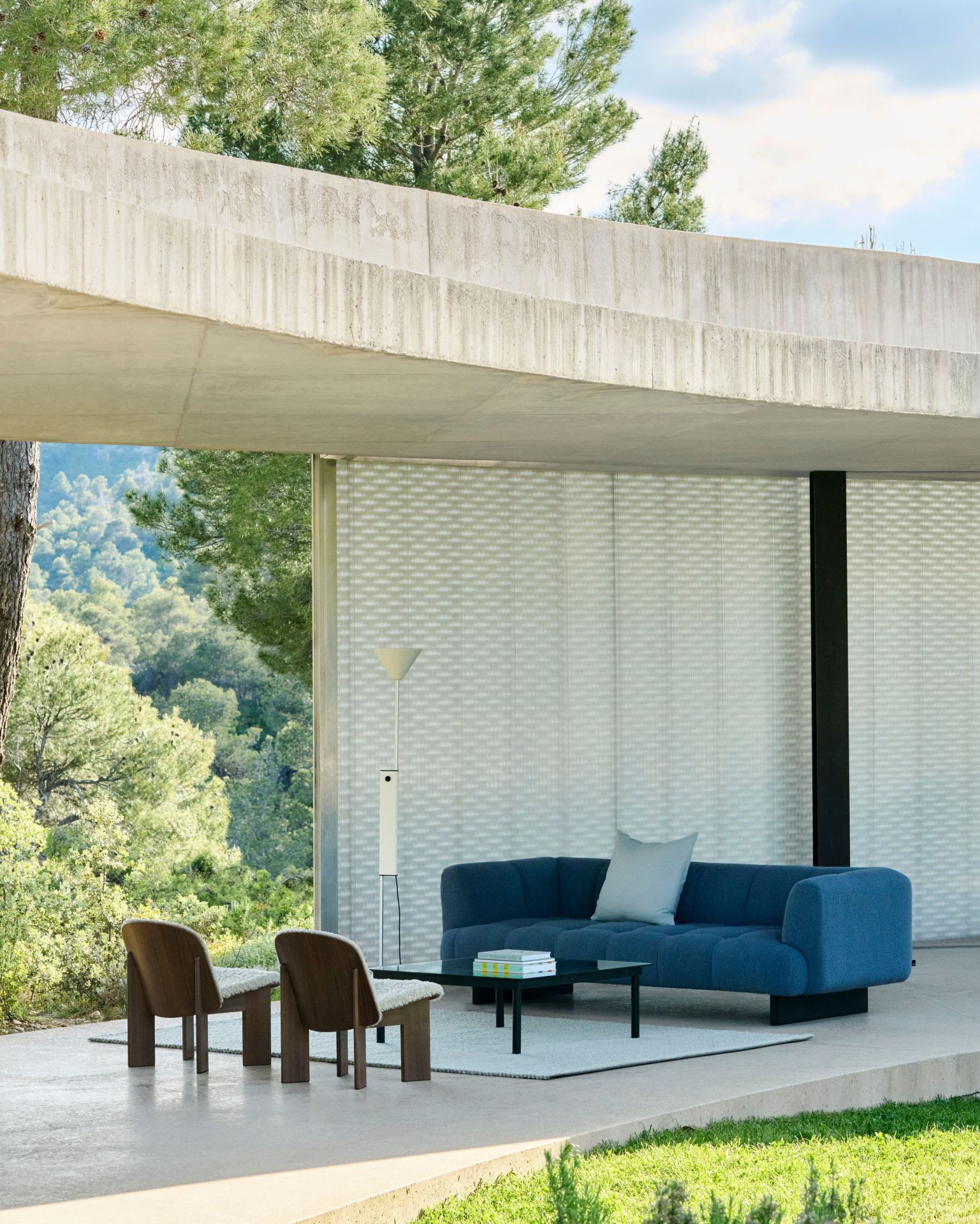 Helle moderne Terrasse mit blauen Sofa, Couchtisch, Stühlen und Hay Twist Floor Lamp Stehleuchte.