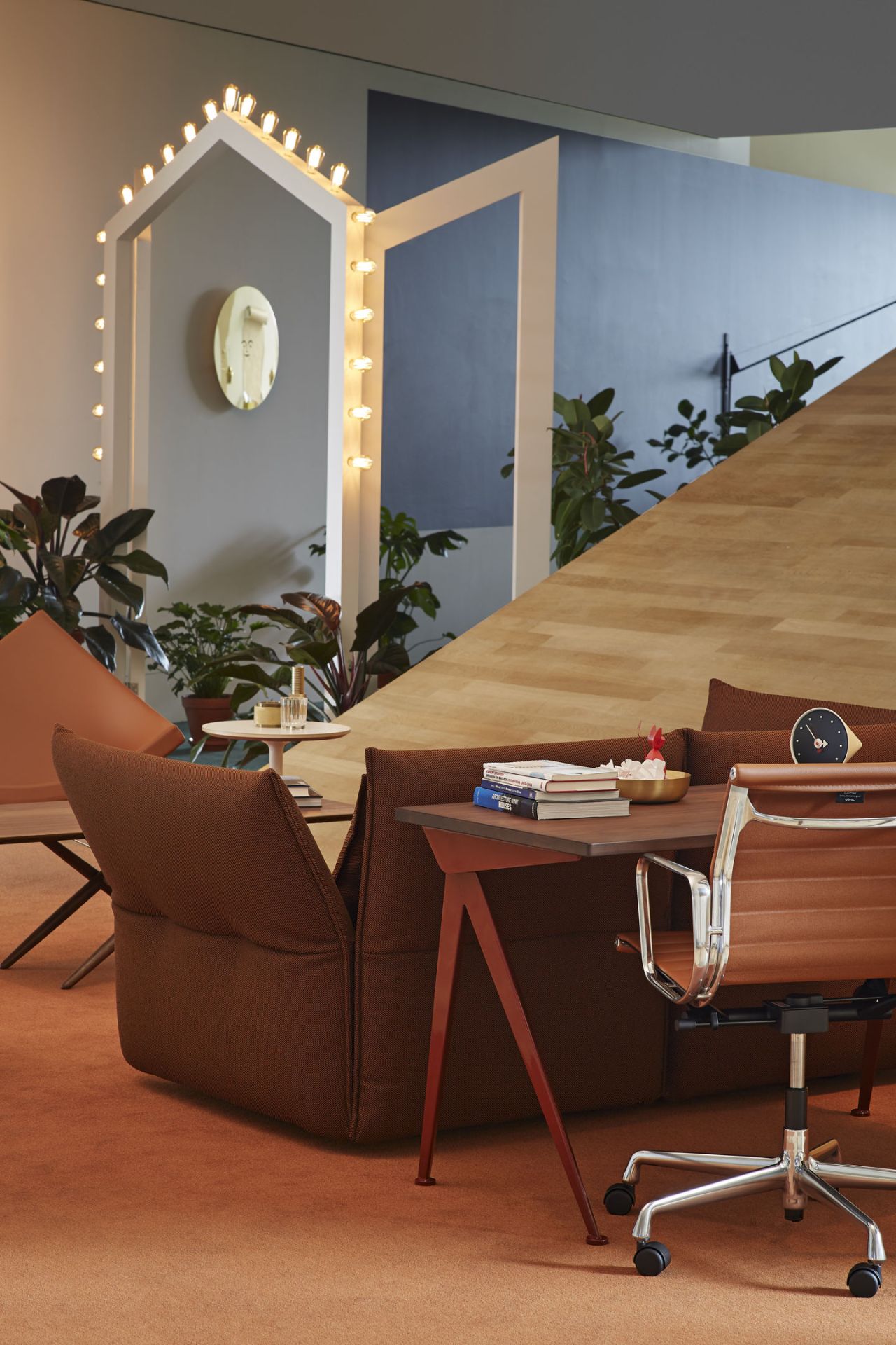 Nahaufnahme eines braunen Vitra Aluminium Chair EA 108 Bürostuhls in einem modernen Büro.