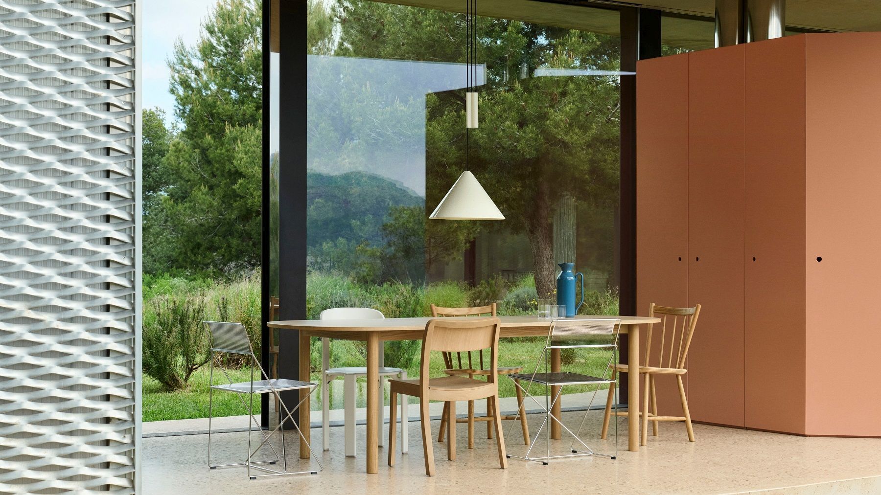 Helle Compass Adjustable Pendelleuchte von Hay über Esstisch mit Stühlen in modernem Esszimmer.