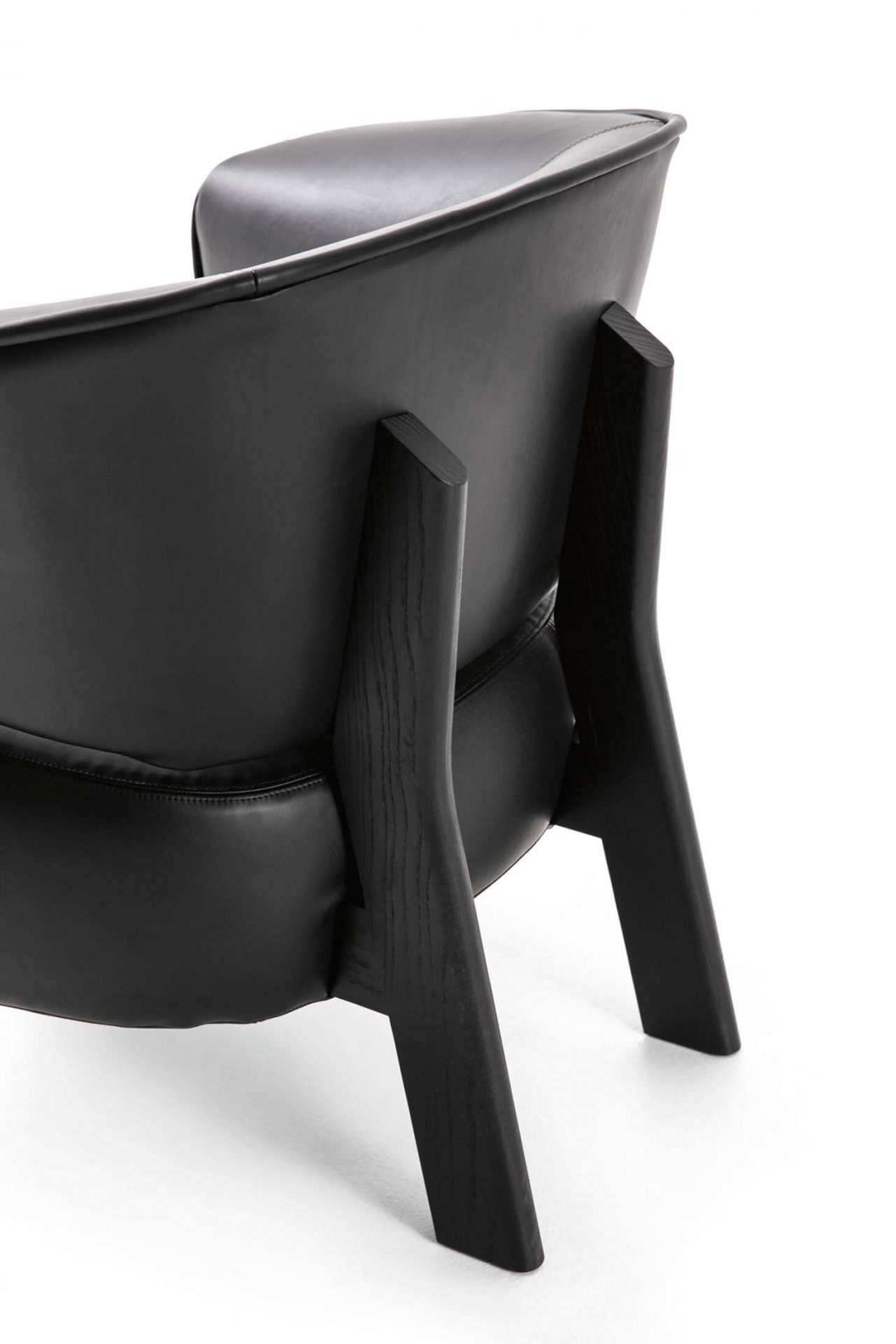 Detailaufnahme der Rückseite des schwarzen Cassina Back-Wing Sessels mit Holzbeinen auf weißem Hintergrund.
