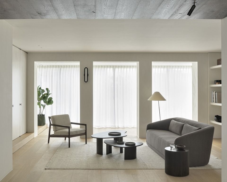 Helles Wohnzimmer mit Ethnicraft Möbeln: Sofa, Sessel, Couchtische und Boomerang Rollcontainer im modernen Design.