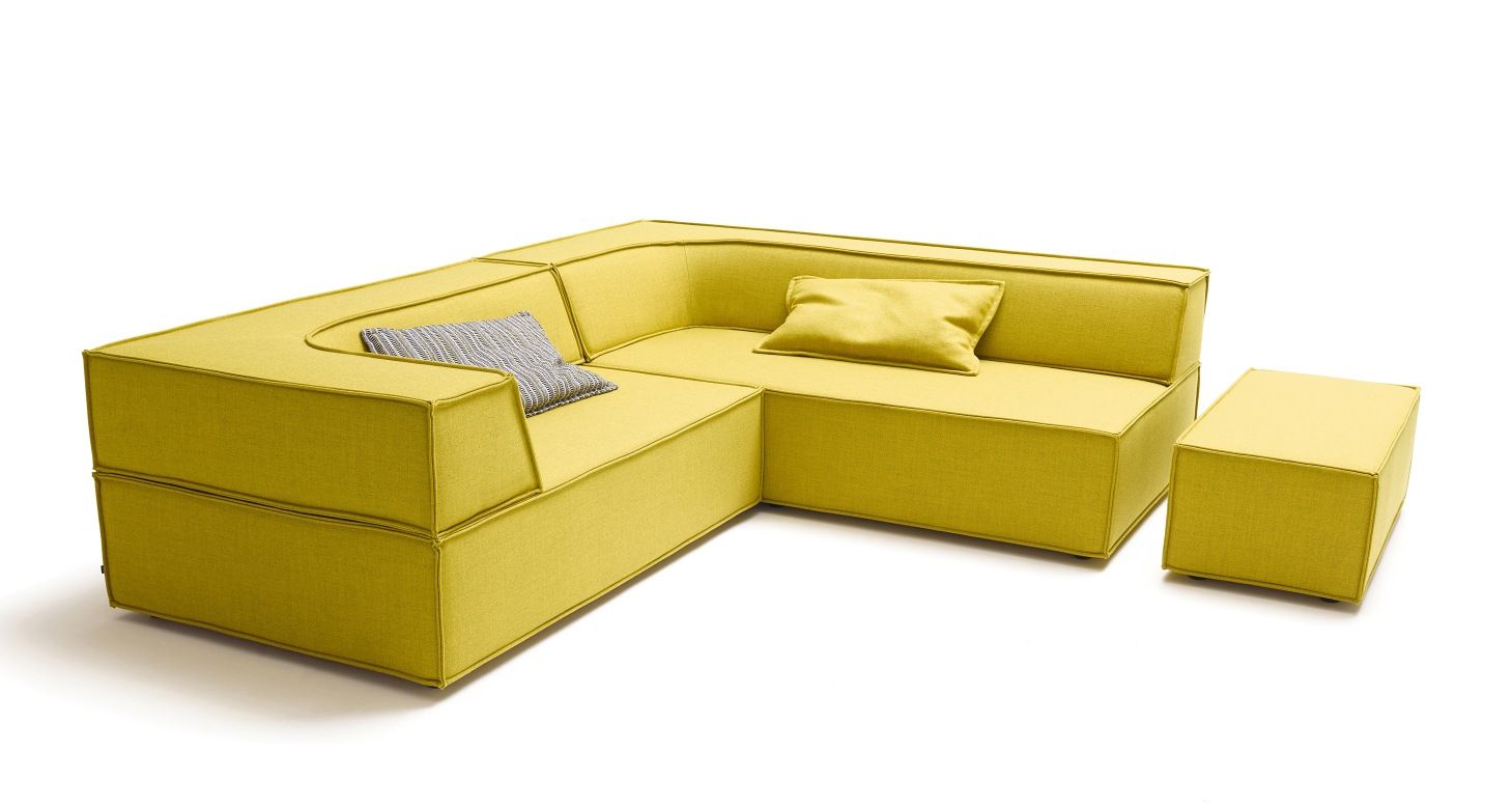 Gelbes Cor Trio Sofa mit Sitzelementen, zwei Kissen und einem Hocker auf weißem Hintergrund.