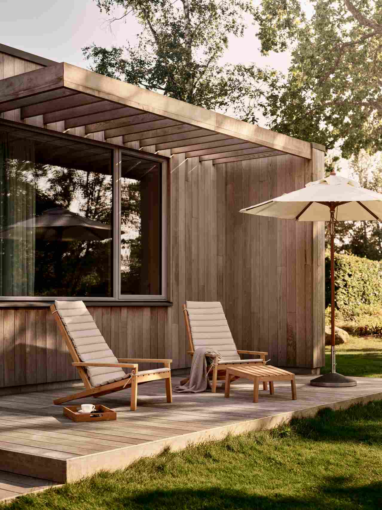 Zwei Liegestühle mit Between Lines Sitzkissen von Skagerak by Fritz Hansen im Garten.