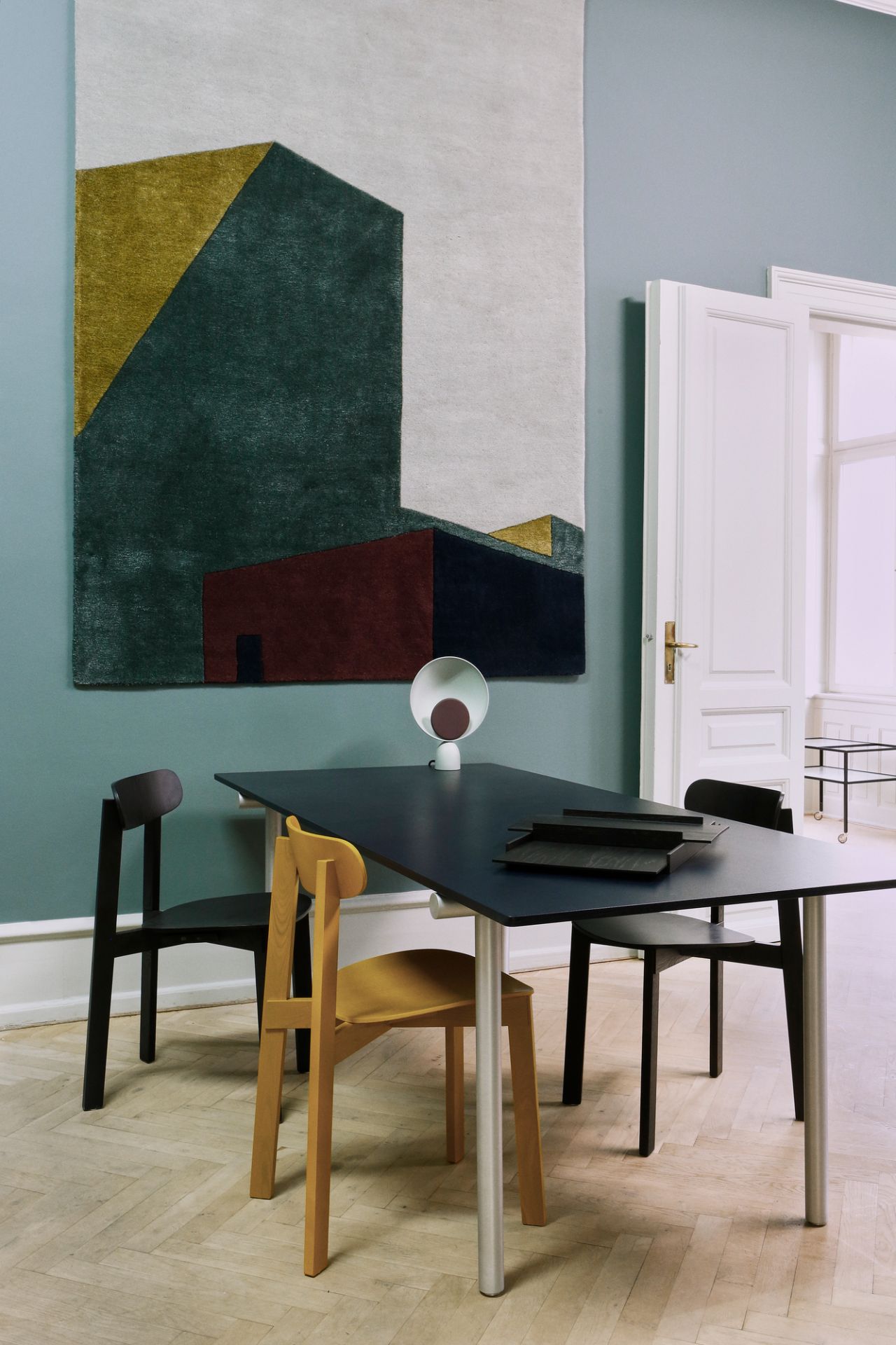 Arqui Teppich von Please Wait to be Seated mit abstraktem, geometrischem Muster an der Wand.