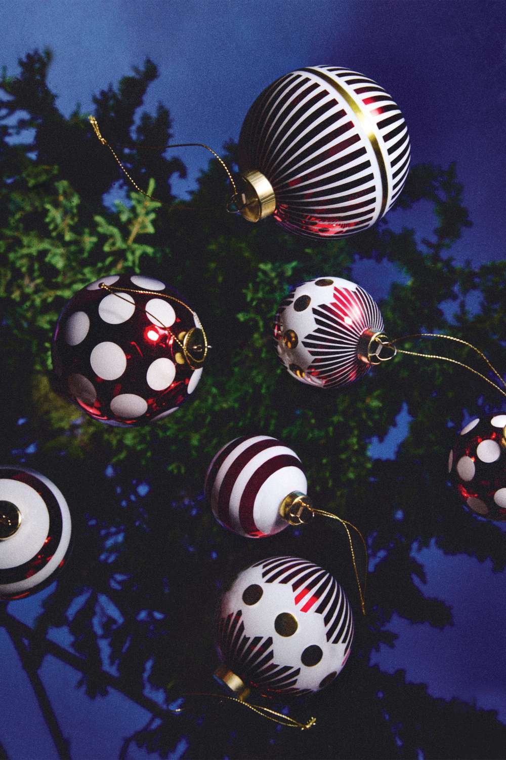Nahaufnahme von Alessi Weihnachtskugeln NZ04 1 Delight mit Streifen- und Punktmuster am Weihnachtsbaum.