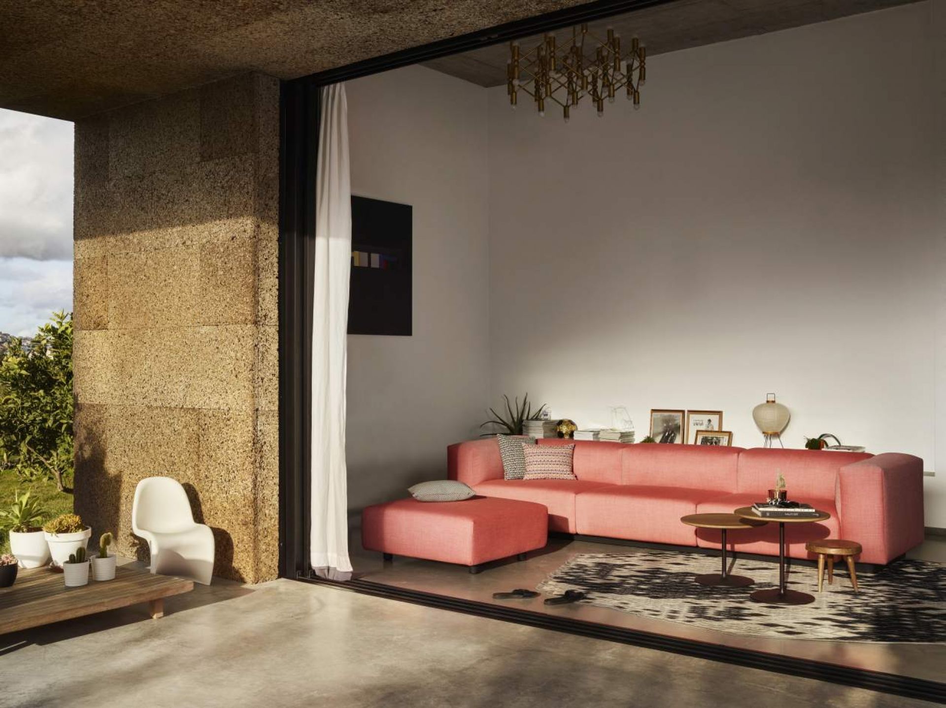 Panton Chair in Zartrosé von Vitra im modernen Wohnraum mit Sofa und Dekoration.