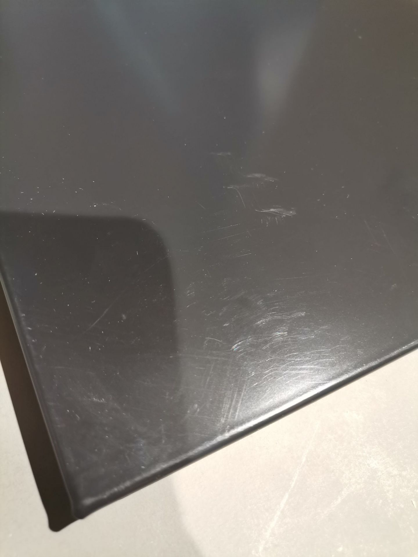 Detailaufnahme einer grauen USM Haller Tischplatte mit Kratzern und Gebrauchsspuren, Mängelexemplar.