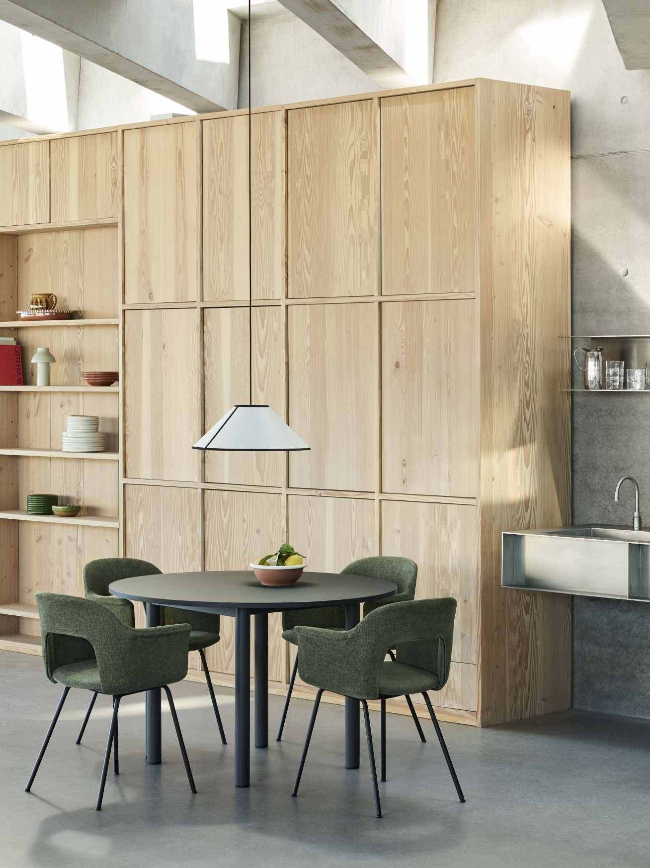 Nahaufnahme von vier grünen Hay Layout Armchair 214 Armlehnstühlen um einen runden Esstisch in modernem Interieur.