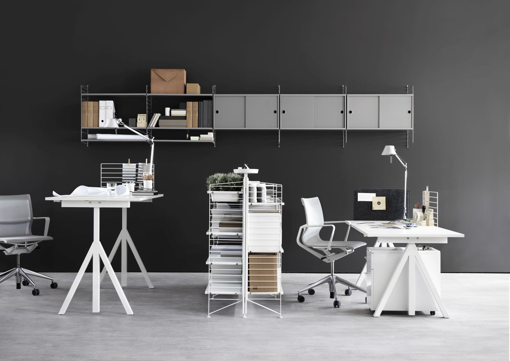 Büro mit String Regalsystem, Schreibtischen und Stühlen. String Furniture Wandleiter in Weiß sichtbar.
