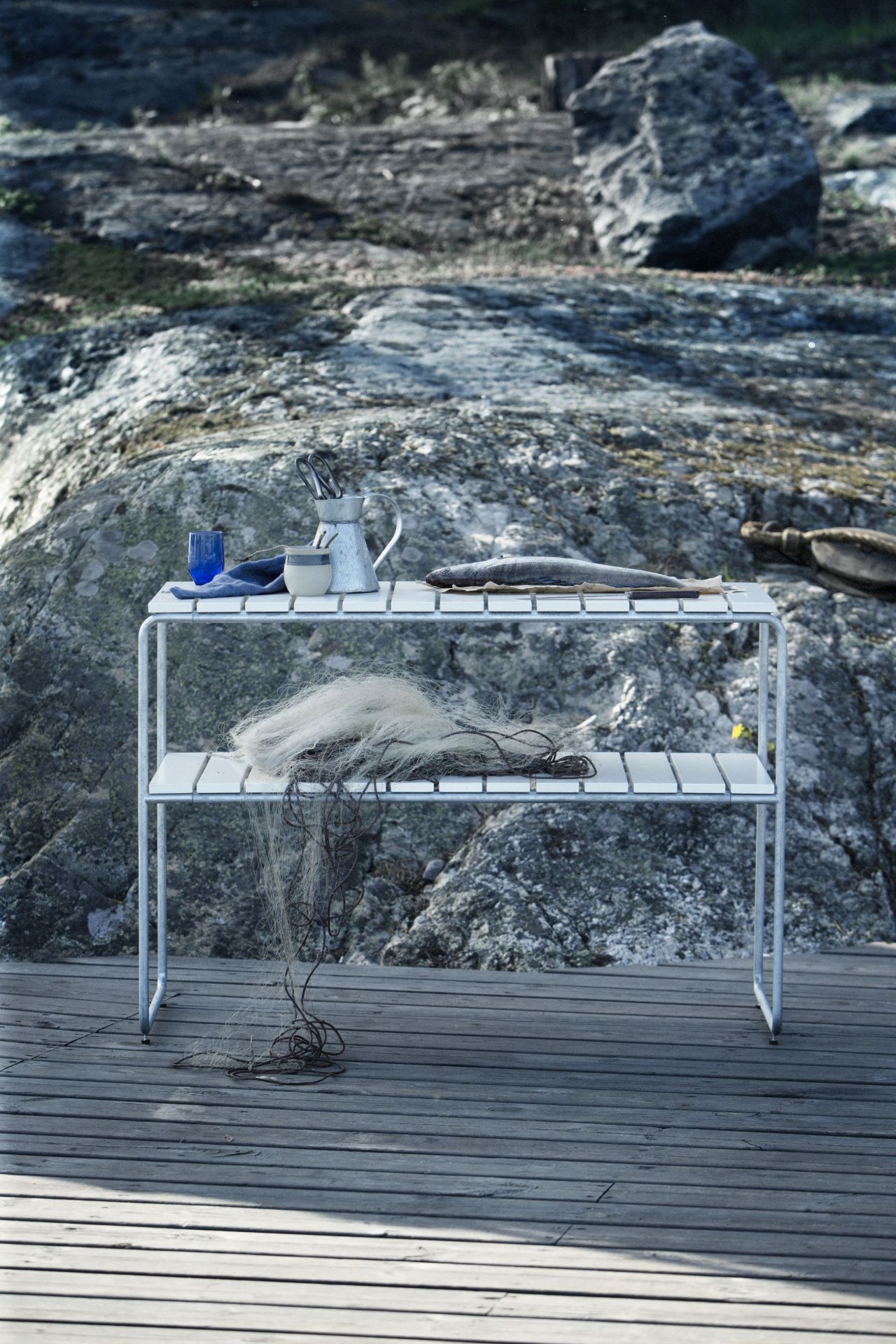 Beistelltisch L105 von Grythyttan Stalmöbler aus Eiche, mit Deko-Objekten auf einer Holzterrasse.