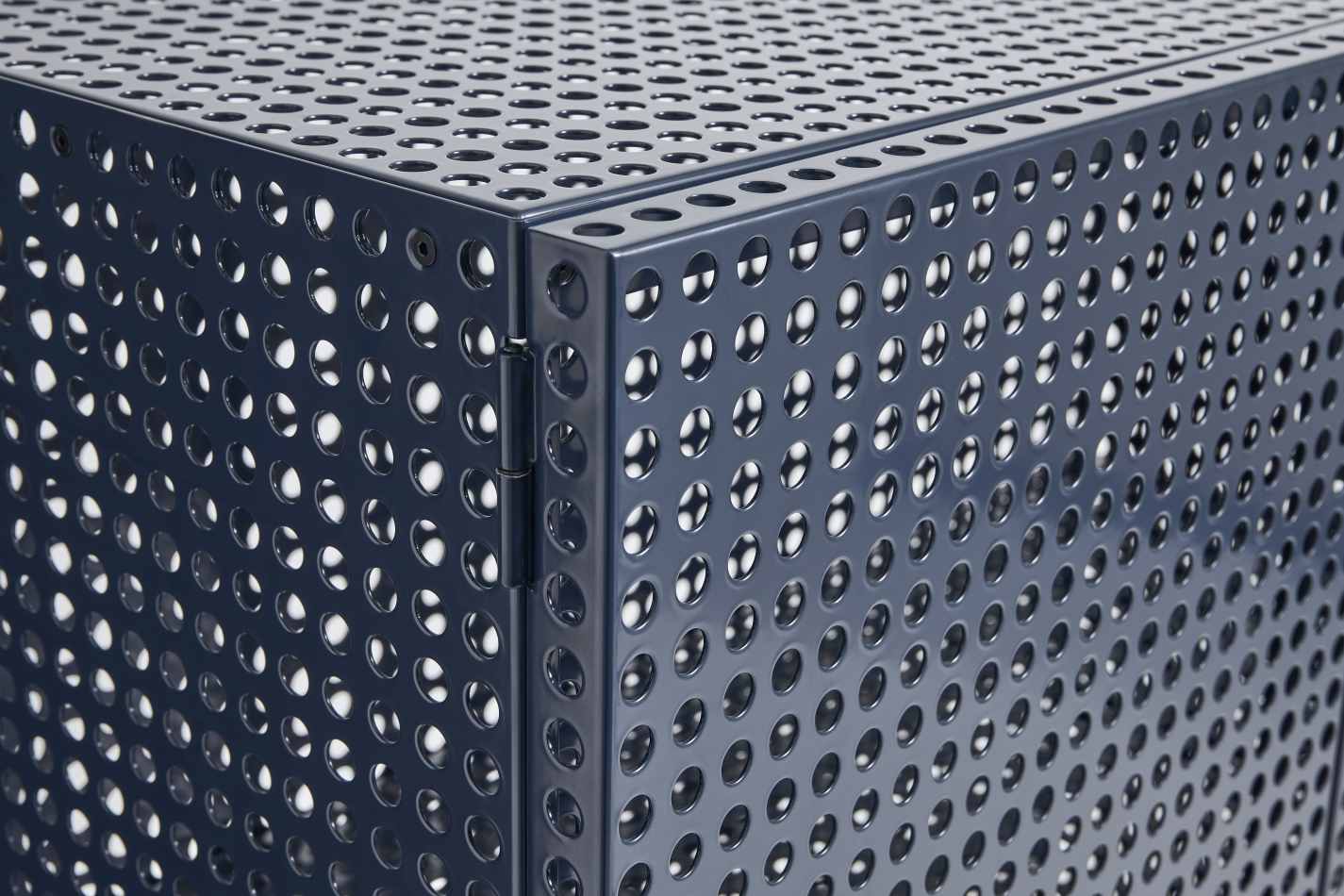 Detailaufnahme des blauen Hay Sideboards "Perforated Cabinet Floor Large" mit Lochmuster und Scharnier.