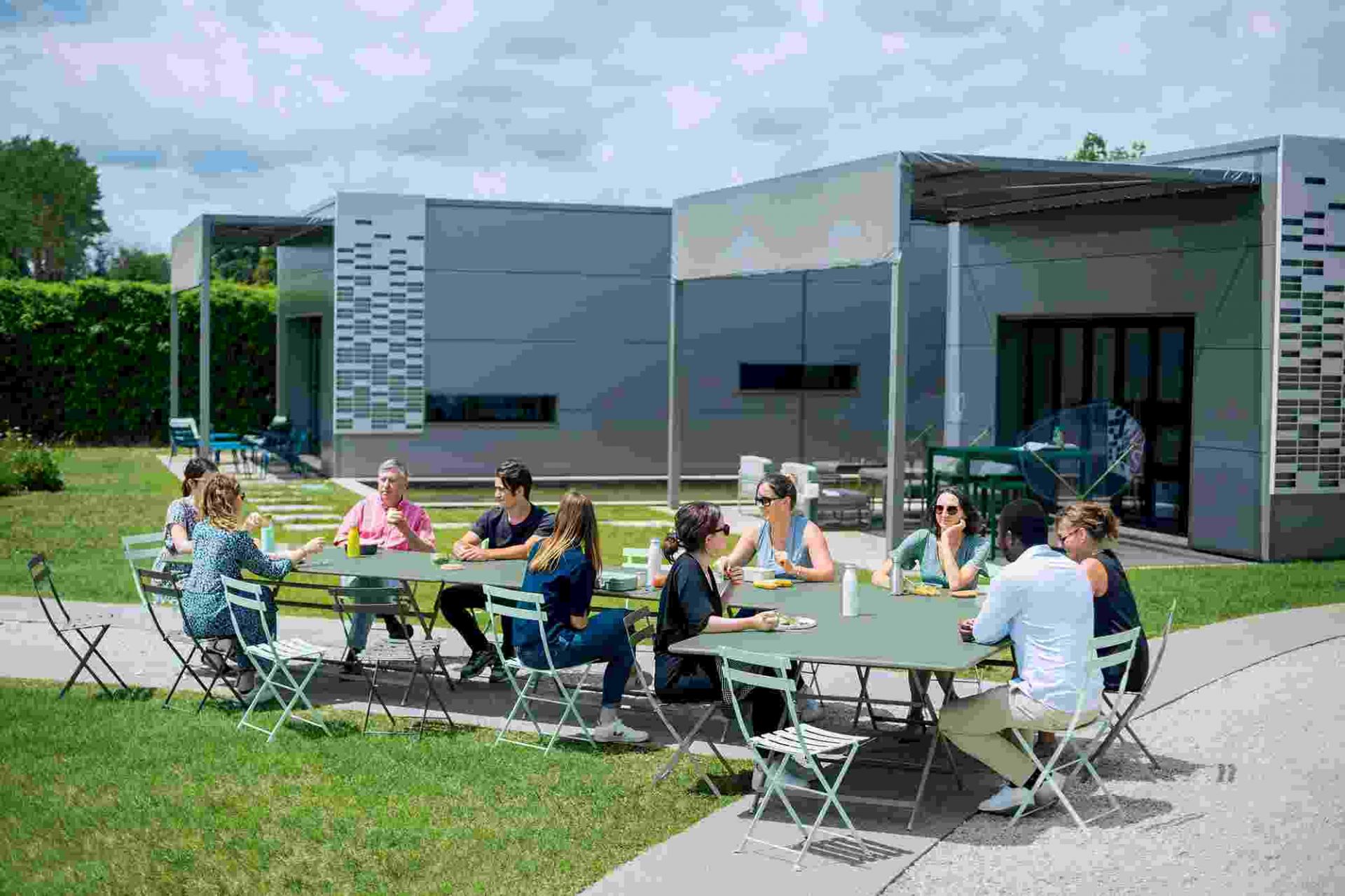 Gruppe sitzt an Gartentisch auf Bistro Stühlen von Fermob, Outdoor Möbel.