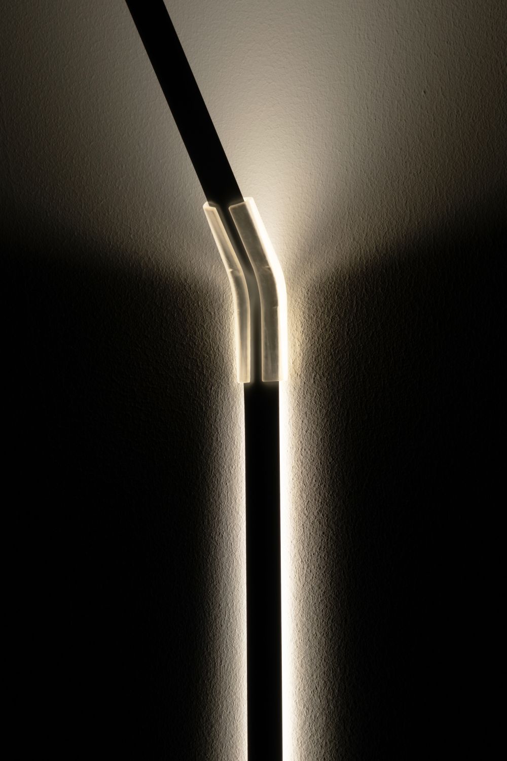 Detailaufnahme der Measure Light Wandleuchte von Ingo Maurer, die ein warmes, indirektes Licht an die Wand wirft.