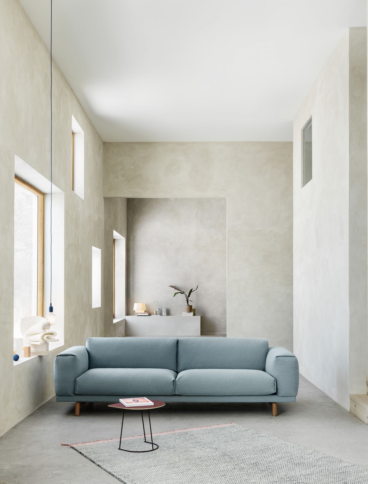 Moderner Wohnraum mit blauem Sofa und kleinem, runden Airy Coffee Table Beistelltisch von Muuto.